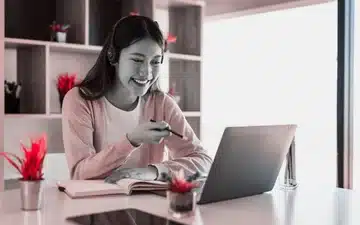 Jeune femme équipée d'un micro casque, installée dans un cadre chaleureux. Des conditions idéales pour une formation SEO personnalisée et sans stress. 